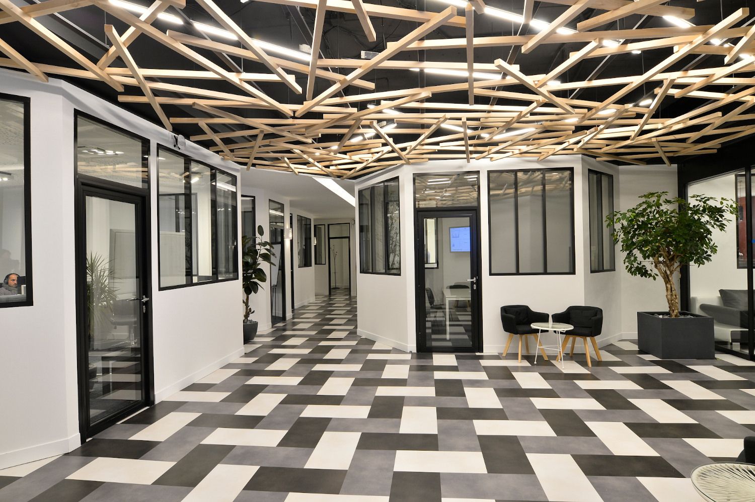 Plateau de bureaux, plafond en tasseaux de bois entrecroisés et sol tissé noir et blanc